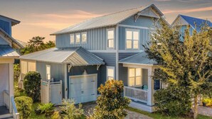A two-story house with a garage, a covered porch, and a well-maintained lawn. - 2 Homes, Sleeps 25 Pool, Firepit, Free Golf Carts Blue Mountain Beach (Santa Rosa Beach)