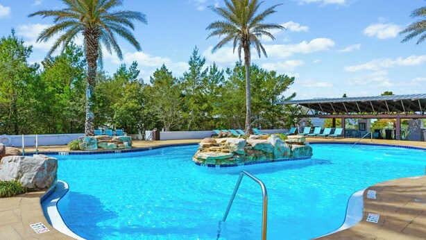 A swimming pool with clear blue water, surrounded by palm trees and lounge chairs. - 2 Homes, Sleeps 25 Pool, Firepit, Free Golf Carts Blue Mountain Beach (Santa Rosa Beach)