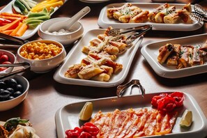 Variedad de alimentos en platos, como pasta, verduras y un plato con carne.