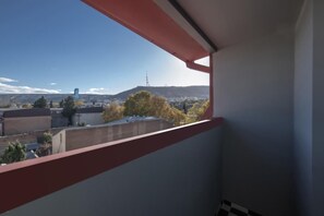 A balcony with a view of a cityscape, including buildings and a hill. - Hotel Twenties Tbilisi - Stay & Dine (Tbilisi)