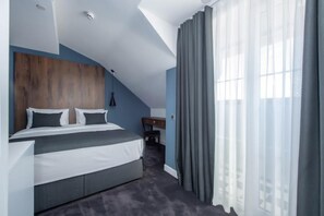 Un dormitorio moderno con cama, escritorio y silla.