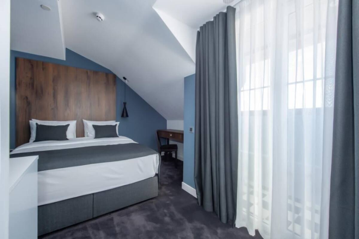 A modern bedroom with a bed, a desk, and a chair.