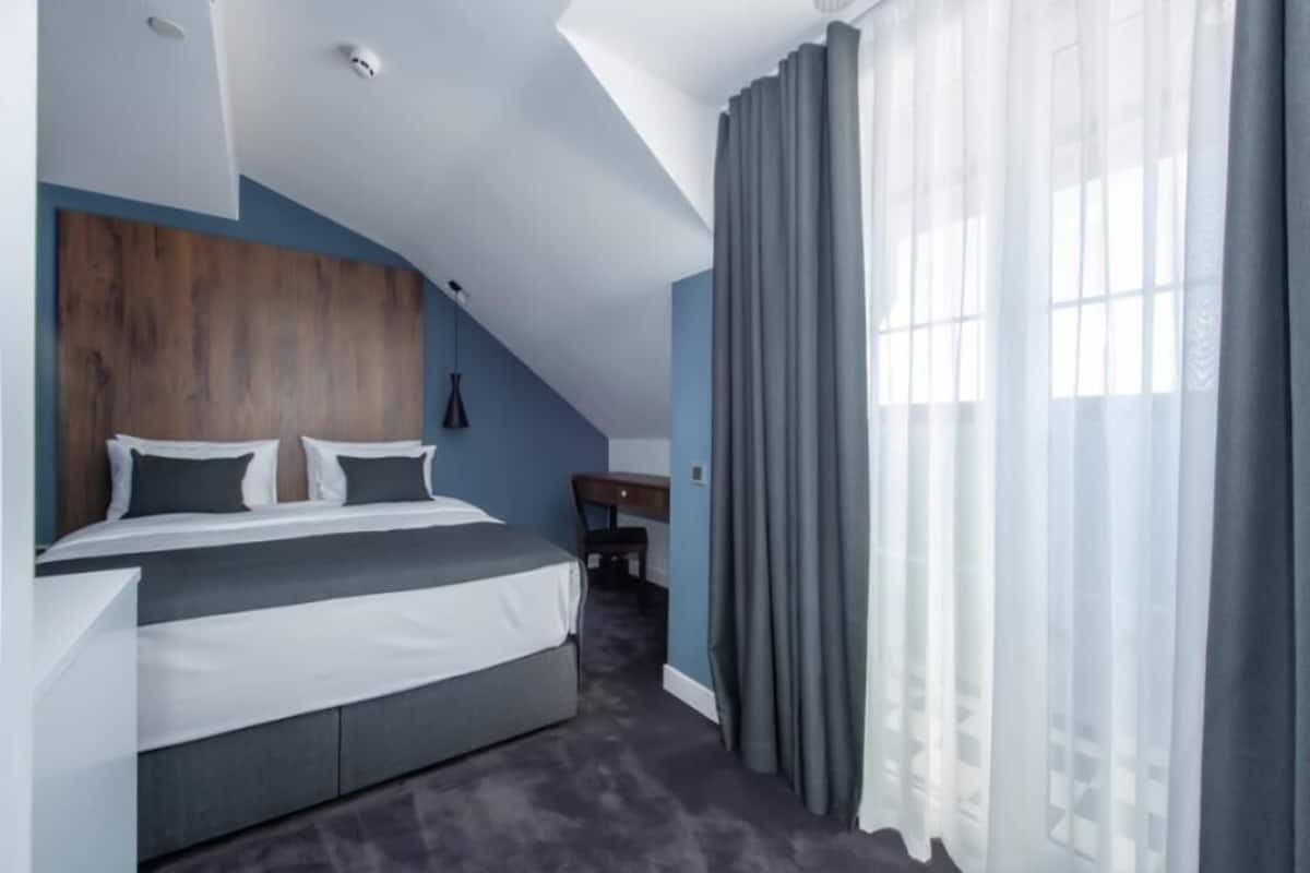 Ein modernes Schlafzimmer mit Bett, Schreibtisch und Stuhl.