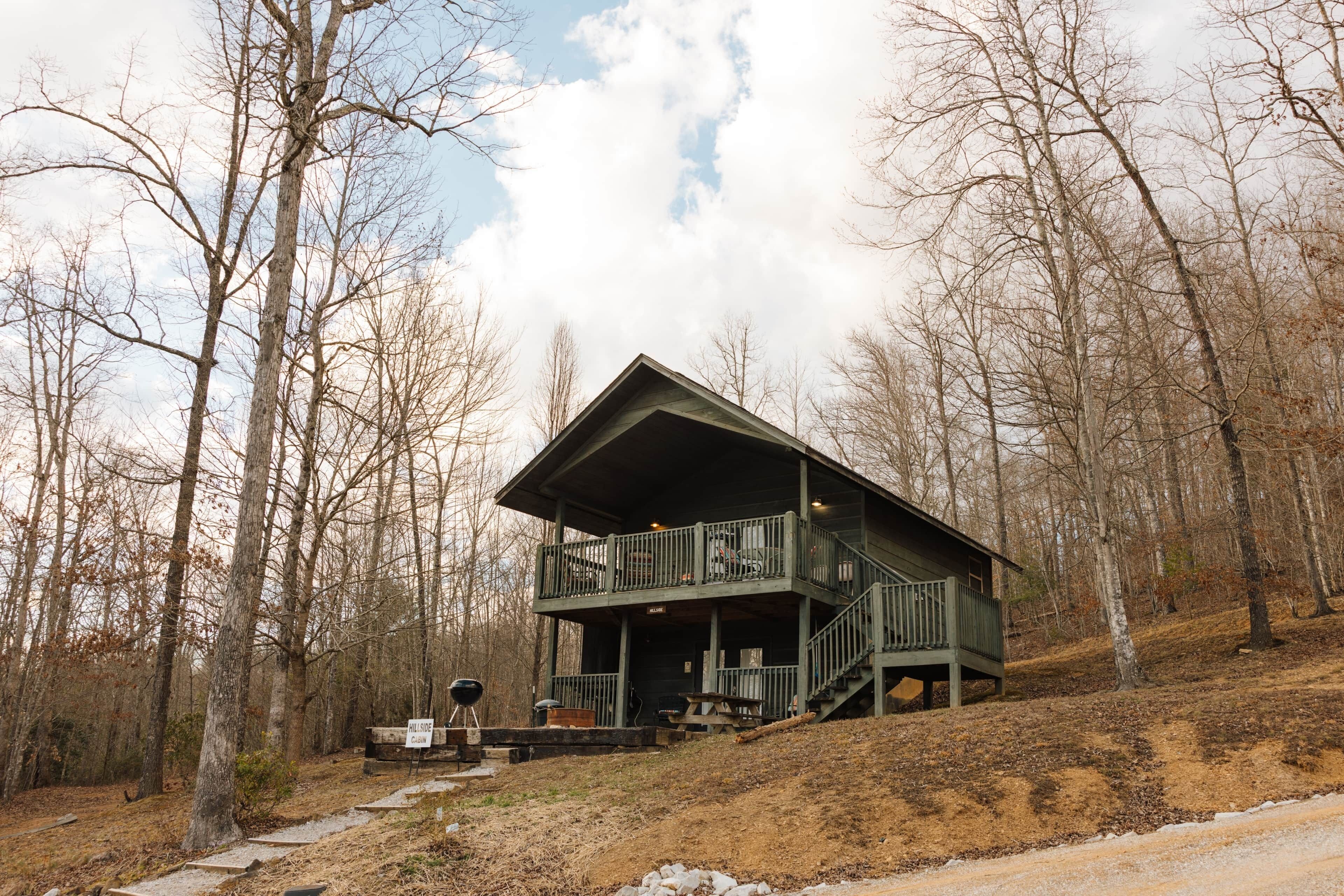 A cabin with a balcony, surrounded by trees.
