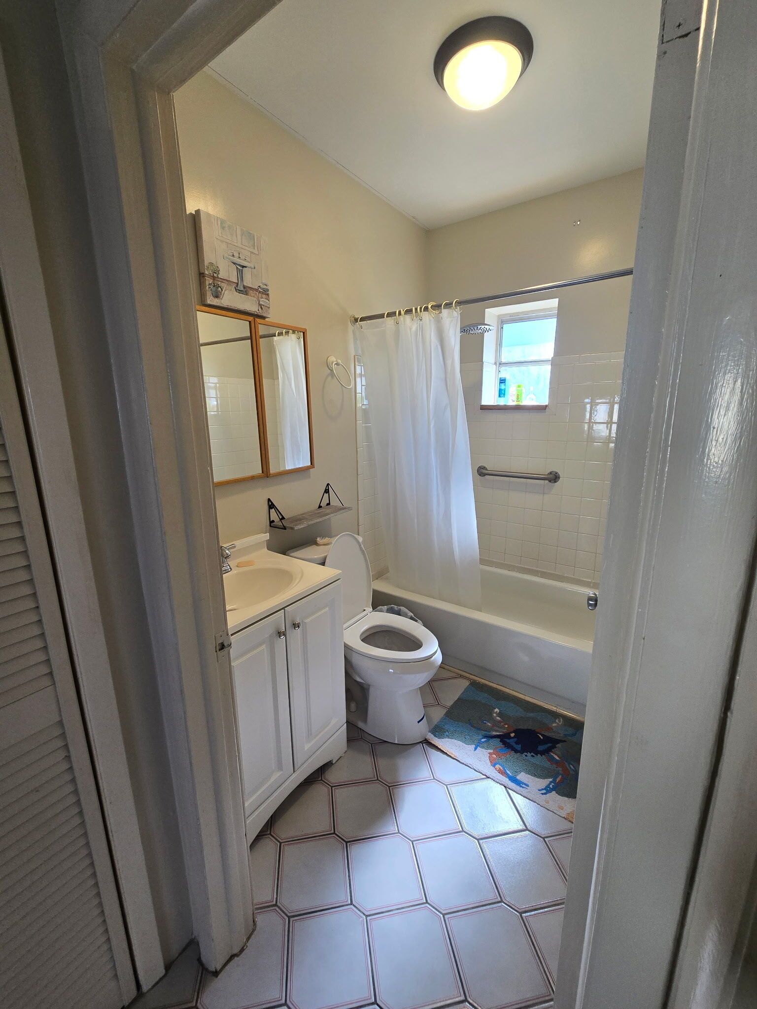 Ein Badezimmer mit Toilette, Waschbecken, Spiegel und Duschvorhang.