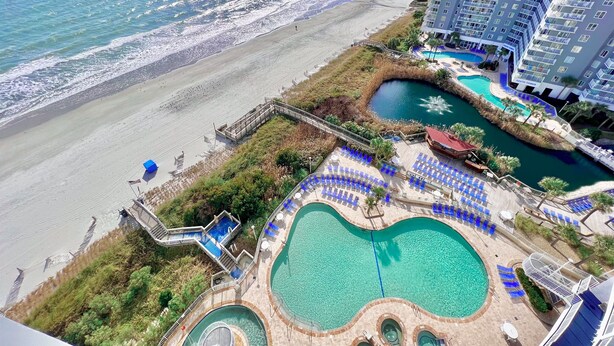 A resort with a beach view, a pool area, and a high-rise building. - Modern Oceanfront Couple Retreat, SeaWatch 1703 NT (Myrtle Beach)