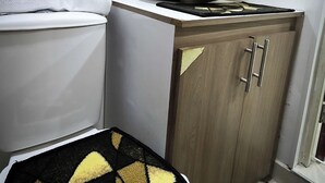 Un bagno con un lavandino bianco, un water, uno specchio e un tappeto decorato.