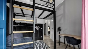 Een kamer met een stapelbed, een bureau en een stoel.