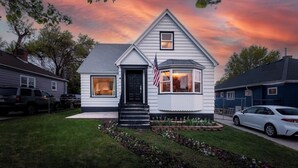A single-story house with a front porch, a garage, and a driveway. - Family Retreat Near Trails & Downtown • BBQ, Fire Pit & Kids’ Games (Ogden)