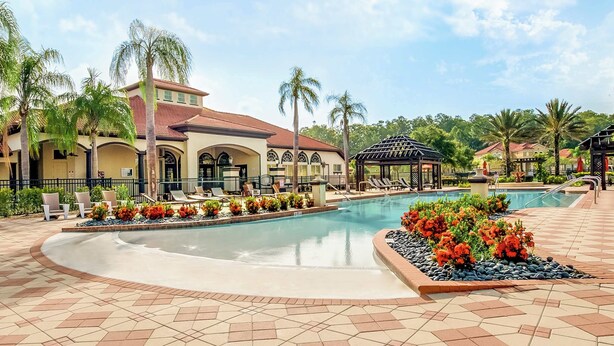 A resort pool area with a tiled deck, lounge chairs, and a gazebo. - Upstay - 18-guest Mansion w Pool, Games, Cinema (Kissimmee)