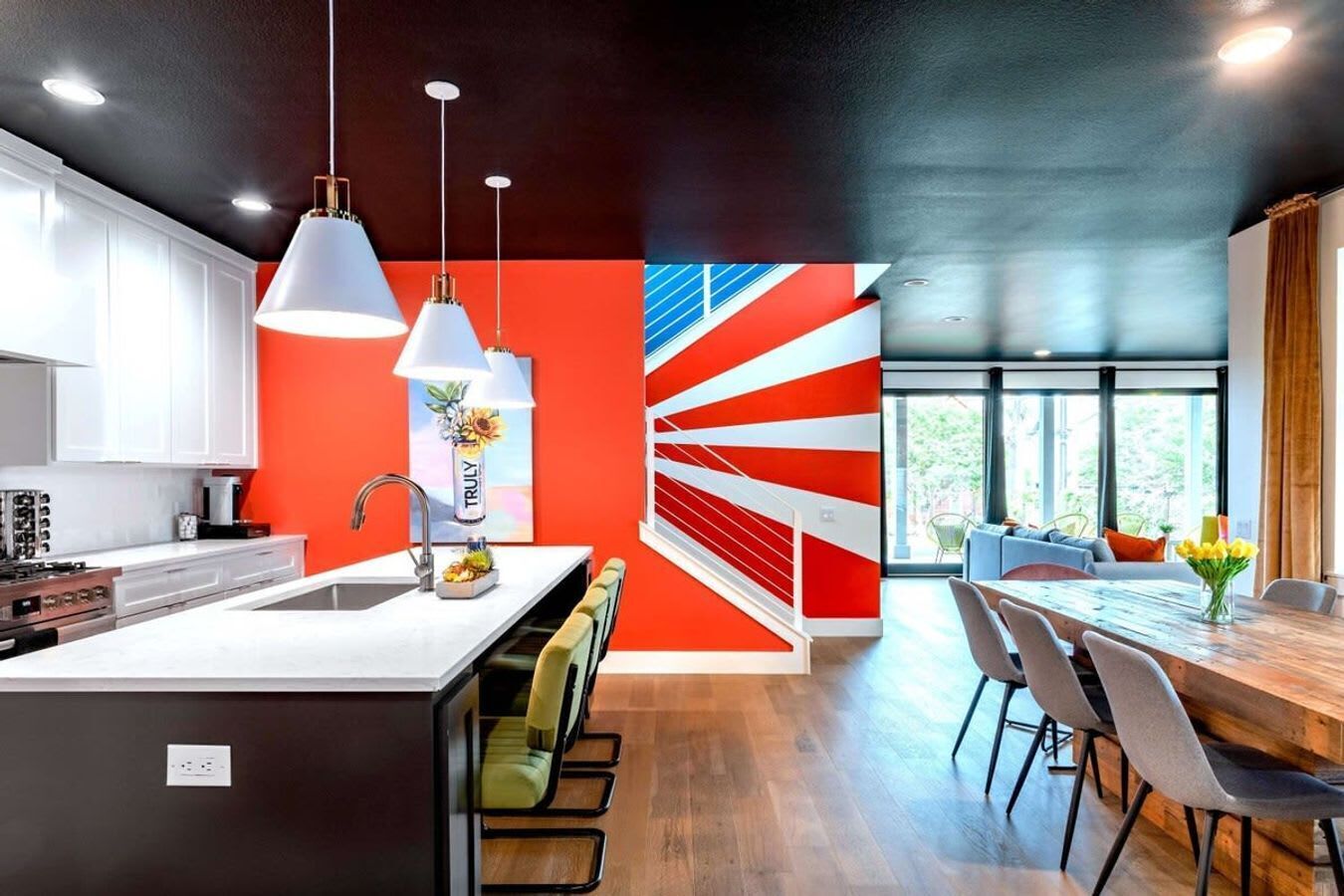 A modern kitchen with white cabinets, a central island, and pendant lighting.