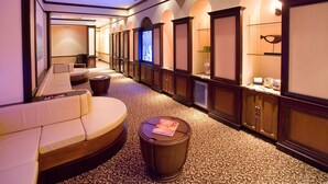 A hotel corridor with a sofa, a round table, and a small stool. - Upstay: Family-friendly Getaway With Spa & Pool (Orlando)