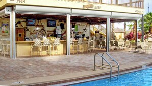 A poolside bar with separate seating for men and women, a pool, and a building with a balcony. - Upstay: Family-friendly Getaway With Spa & Pool (Orlando)