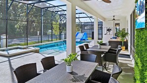 Ein überdachter Außenbereich mit Pool, Sitzgelegenheiten und einer Rutsche.