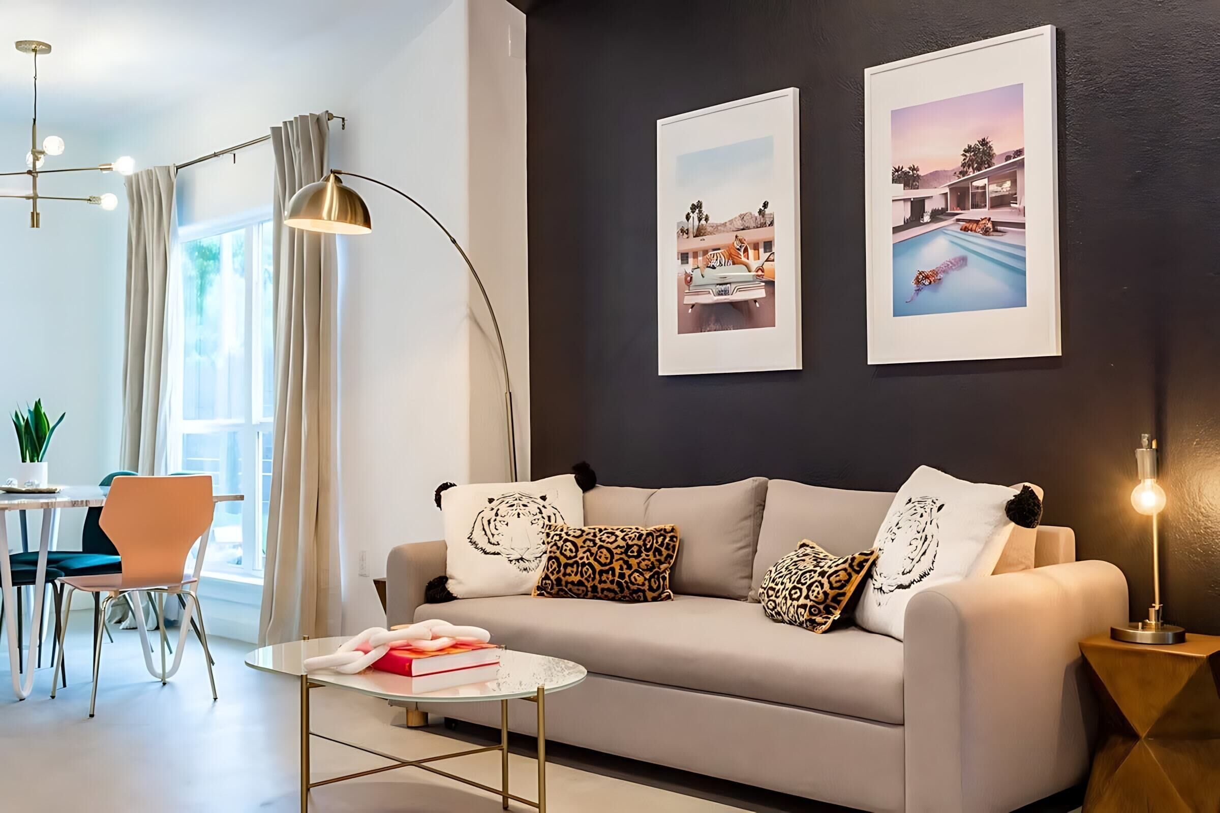 A modern living room with a sofa, a round coffee table, and a dining area with a table and chairs.