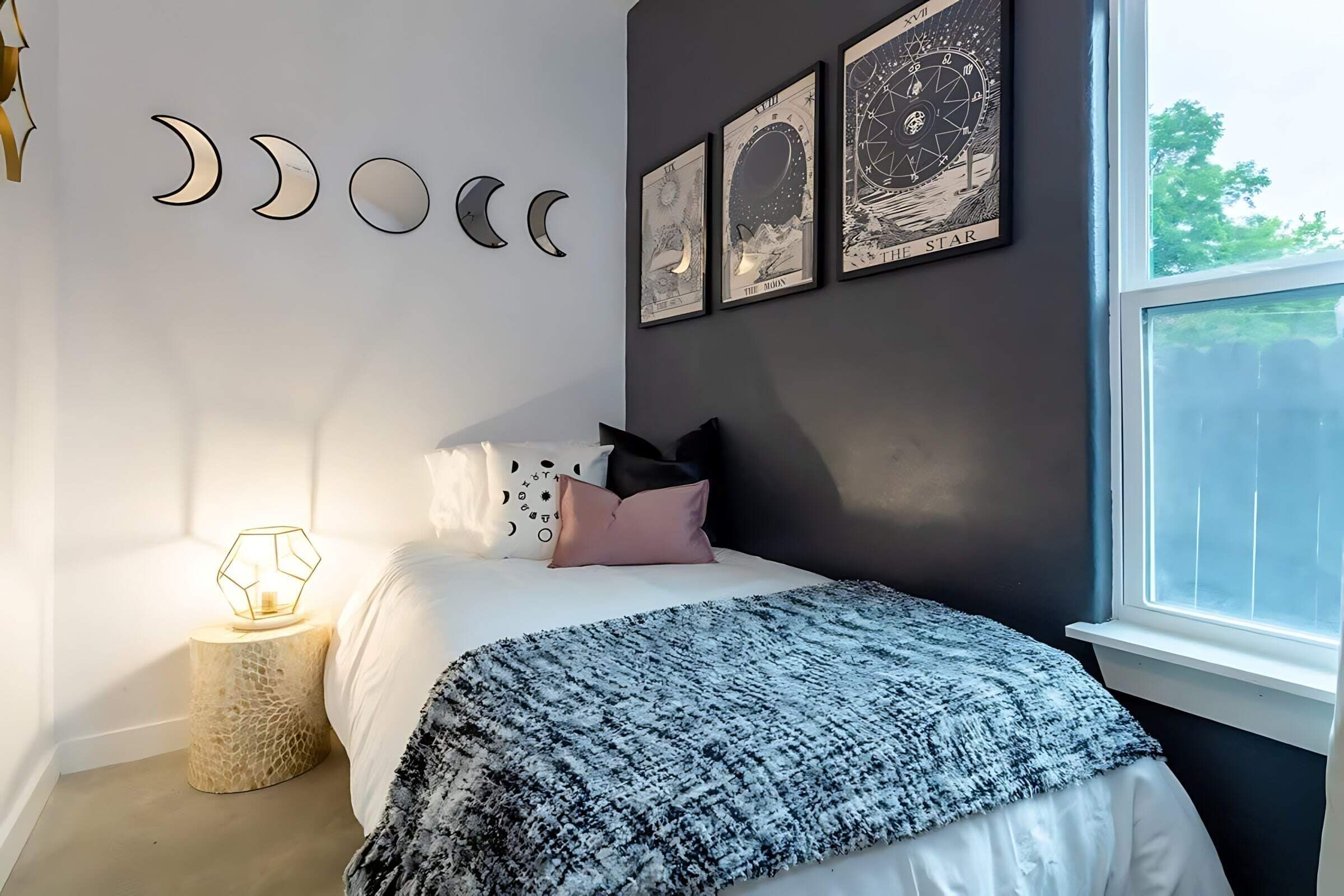 A bedroom with a bed, a nightstand, a window, and wall art.