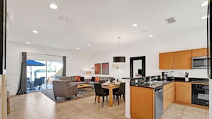 Un appartement moderne comprenant un coin repas, une cuisine et un salon.