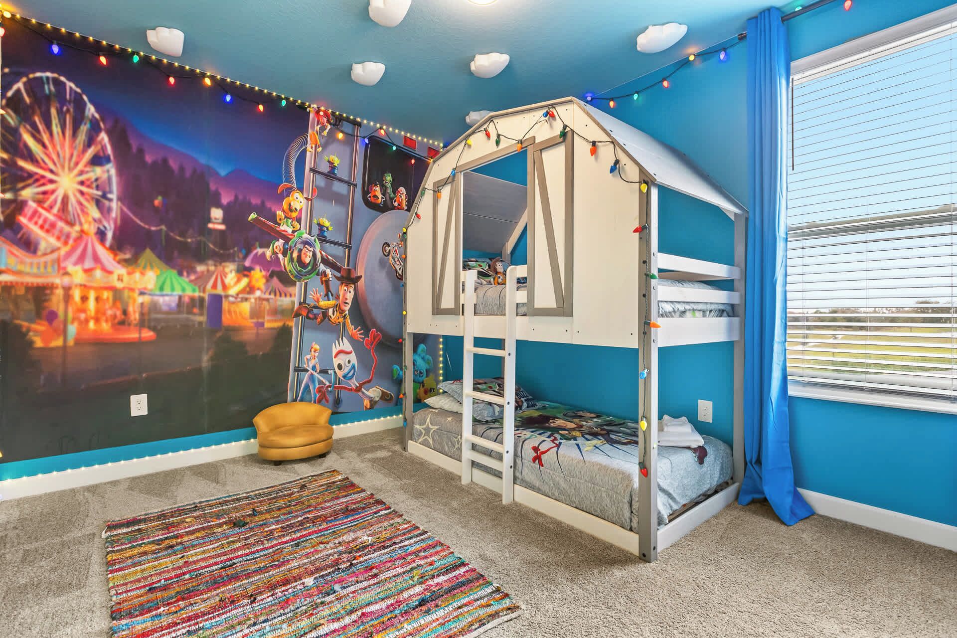Ein Kinderzimmer mit Etagenbett, Wandmalerei mit Zeichentrickfiguren, Riesenrad und Karussell.