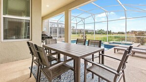 A covered patio with a pool, outdoor furniture, and a view of a residential area. - Upstay: Poolside Mansion w/ Themed Arcade & Cinema (Four Corners)