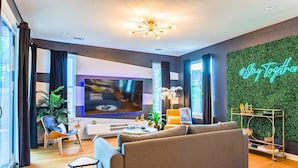 Una sala de estar moderna con un sofá, televisor y objetos decorativos.