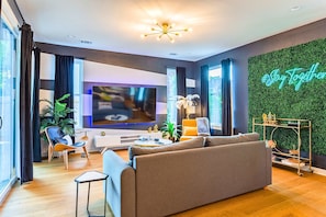 Uma sala de estar moderna com sofá, televisão e objetos decorativos.
