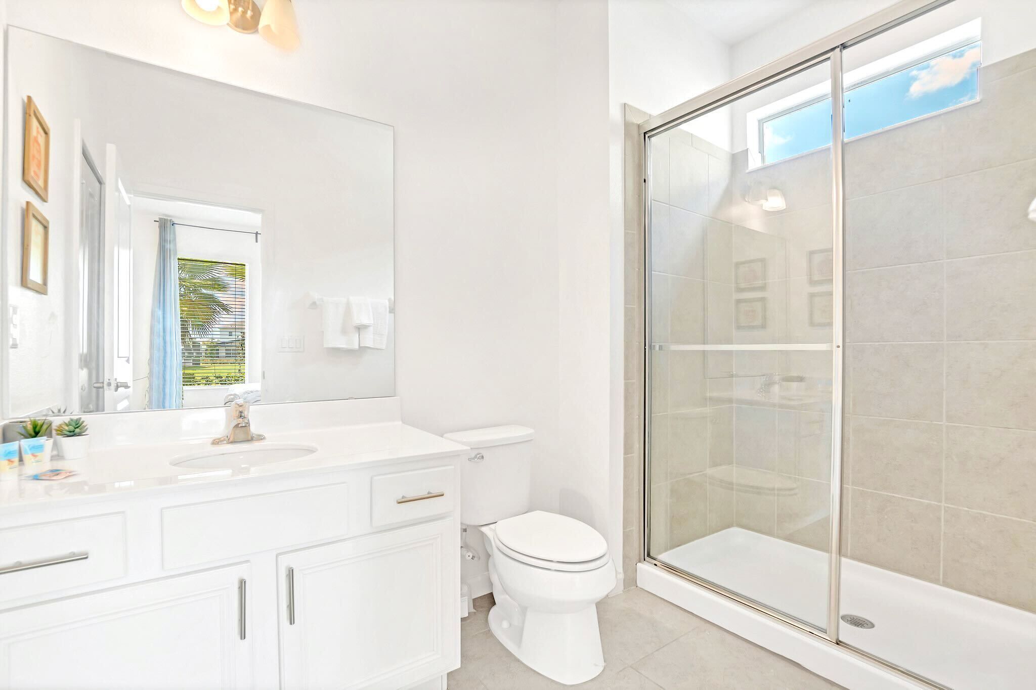 A modern bathroom with a glass shower enclosure, a white sink, and a toilet.