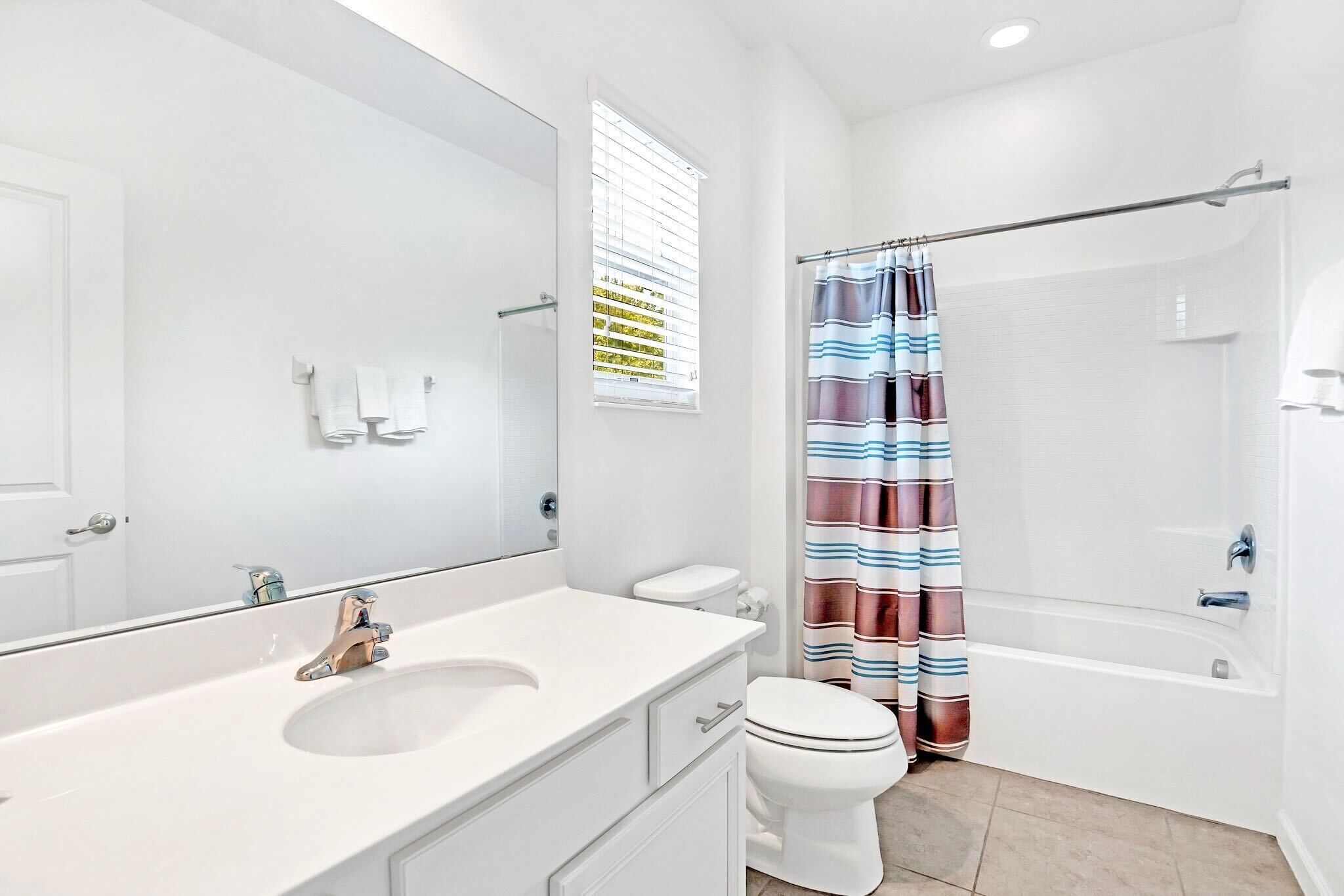 A modern bathroom with a white sink, toilet, and bathtub.