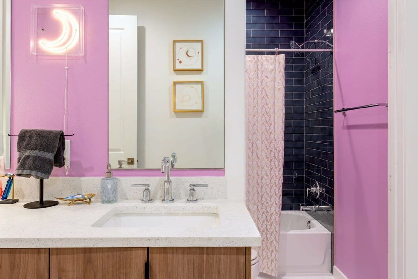 A bathroom with a white sink, two faucets, a mirror, and a shower curtain.