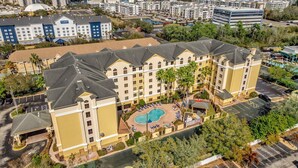 Ein mehrstöckiges Hotel mit Innenhof, der einen Pool beherbergt, umgeben von Gästezimmern und Einrichtungen.