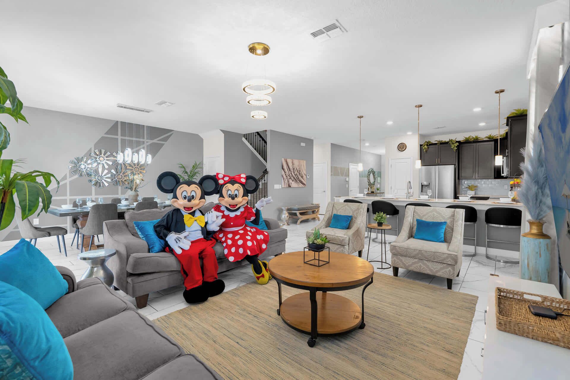 A modern living room with a grey sofa, a round coffee table, and a dining area with a glass table.
