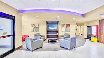 Um hall com assentos, televisão e um posto de venda de bilhetes.