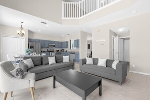 Een ruime woonkamer met een grijze modulaire bank, een salontafel en een grijze fauteuil.