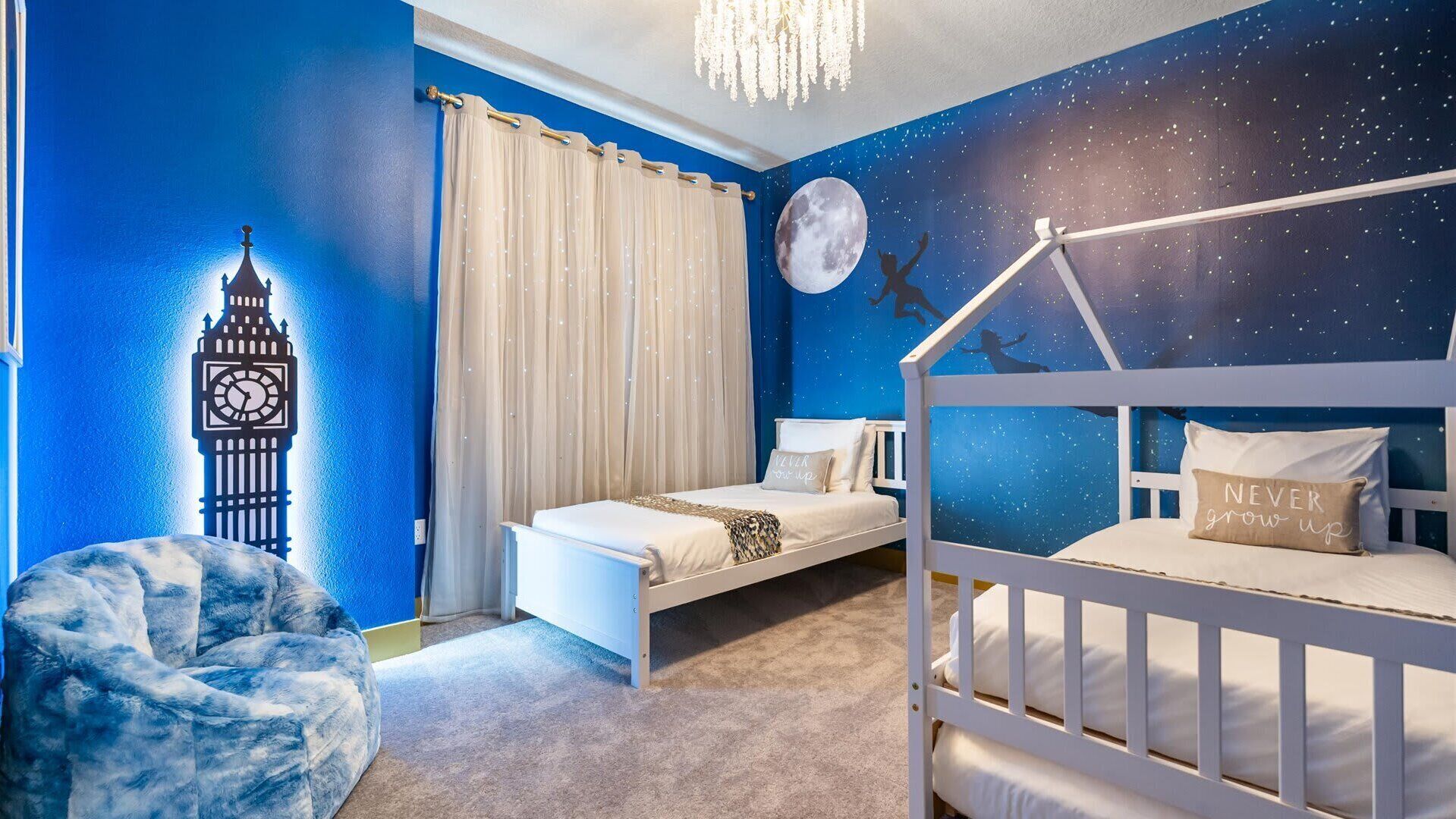 Camera da letto per bambini con un letto a castello, un murale raffigurante un cielo notturno, una luna e una torre dell'orologio.