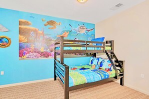 Uma cama beliche com um mural colorido de criaturas marinhas na parede ao fundo.