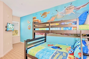 A child's bedroom with bunk beds, a mural of sea creatures, and a television on the wall. - Upstay - Large Condo Near Disney w Pool and Gym (Winter Garden)