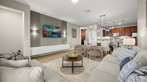Una sala moderna con un conjunto de sofás, una mesa de centro y una zona de comedor con sillas.