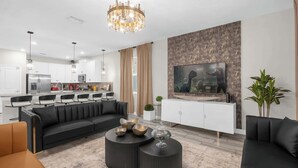 Una sala de estar moderna con sofá, mesa de centro y televisor.