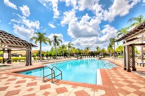 A swimming pool with lounge chairs, palm trees, and a clear sky. - Spacious 4BR Family Townhouseprivate Pool & BBQ (Kissimmee)