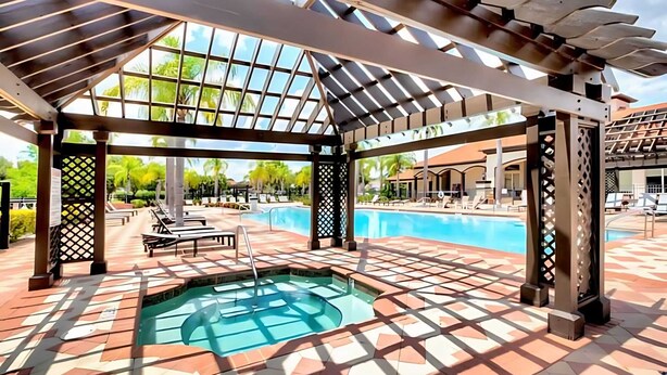 A covered outdoor swimming pool with a pergola, lounge chairs, and a hot tub. - Spacious 4BR Family Townhouseprivate Pool & BBQ (Kissimmee)