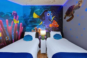 A room with two beds, a nightstand, and a mural of underwater scenes including fish and a turtle. - Upstay: Crystal Cove Resort Villa w/ Pool & Games (Kissimmee)