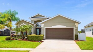 A residential house with a garage, a covered porch, and a well-maintained lawn. - Upstay: Crystal Cove Resort Villa w/ Pool & Games (Kissimmee)