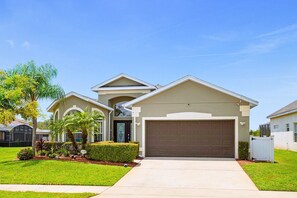 A residential house with a garage, a covered porch, and a well-maintained lawn. - Upstay: Crystal Cove Resort Villa w/ Pool & Games (Kissimmee)
