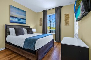 Une chambre d’hôtel avec un grand lit, un bureau, une télévision et une fenêtre avec des rideaux.