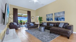 A spacious living room with two sofas, a coffee table, and a TV. - Upstay: Crystal Cove Resort Villa w/ Pool & Games (Kissimmee)