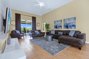 A spacious living room with two sofas, a coffee table, and a TV. - Upstay: Crystal Cove Resort Villa w/ Pool & Games (Kissimmee)