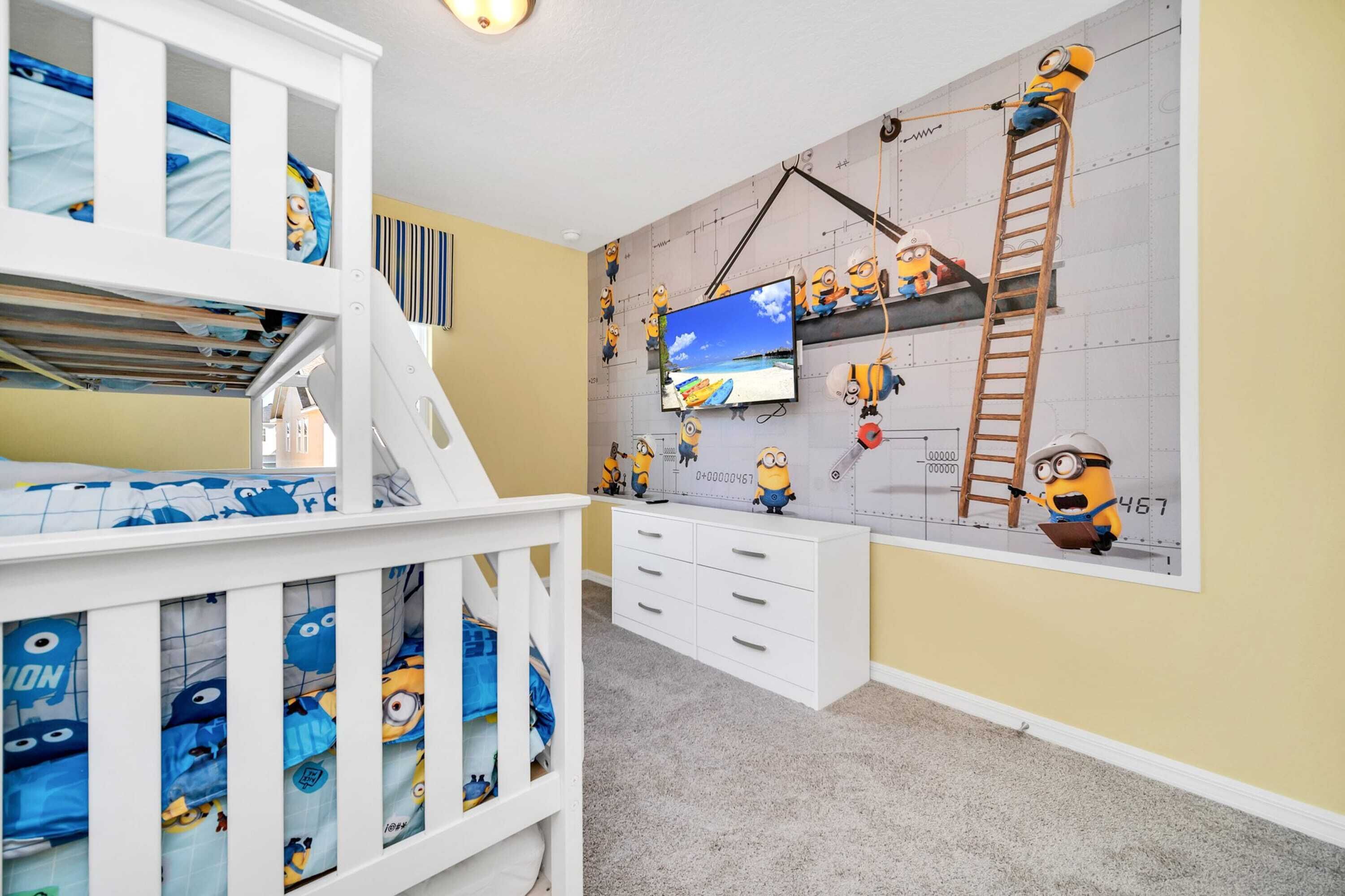 A child's bedroom with a bunk bed, a TV, and Minion-themed decorations.