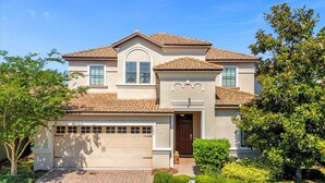 A two-story house with a garage, a front door, and a tiled roof. - Upstay Pool Paradise Mansion Games Room & BBQ (Davenport)