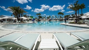 A swimming pool with lounge chairs and palm trees. - Upstay Family Fun 5BR Retreat w Pool & Games Room (Clermont)