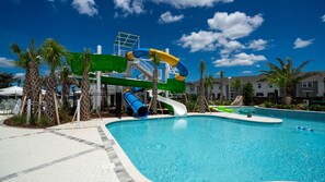 A swimming pool with a water slide and palm trees. - Upstay Family Fun 5BR Retreat w Pool & Games Room (Clermont)