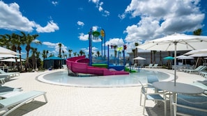A pool area with a water slide, lounge chairs, umbrellas, and palm trees. - Upstay Family Fun 5BR Retreat w Pool & Games Room (Clermont)
